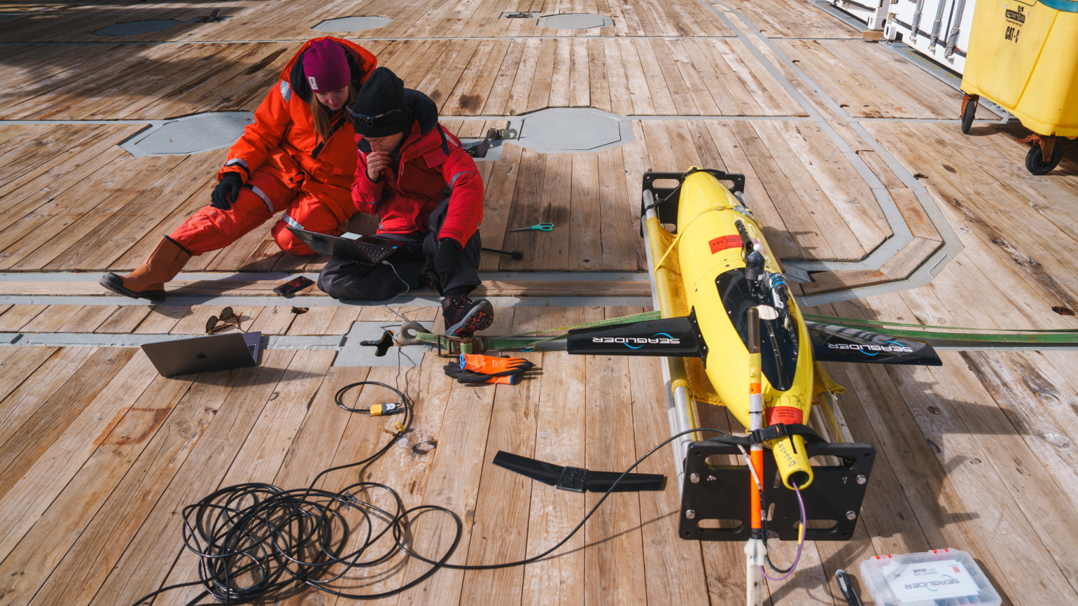 Laura Cimoli (right) and Meredith Meyer (left) make the final communication checks before the deployment of an underwater glider in Antarctica.