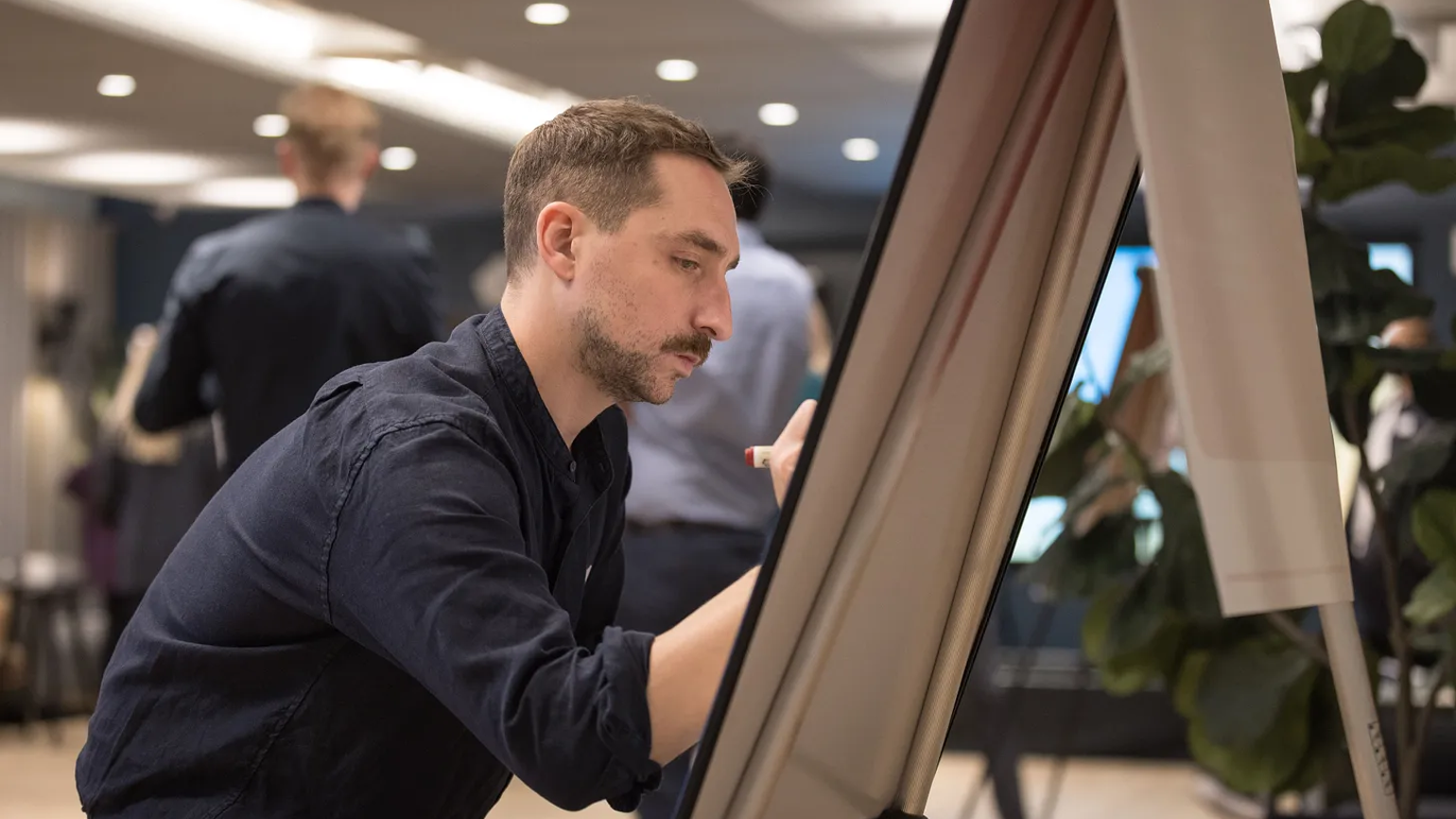 A photo of Jacques writing on a white board.
