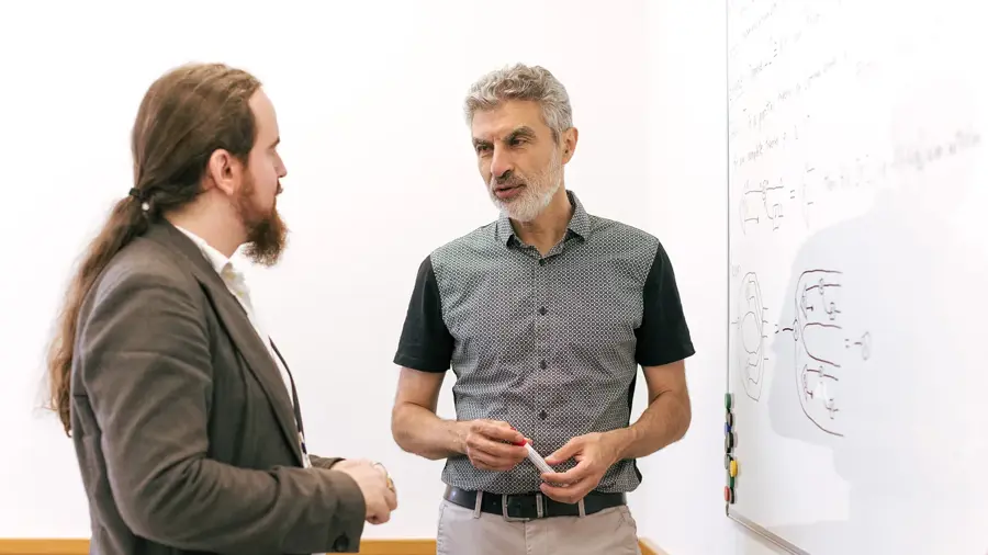 A photo of Yoshua Bengio and Davidad Dalrymple standing in front of a white board