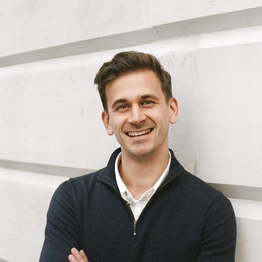 A photo of Fabrizio smiling and standing in front of a white background.